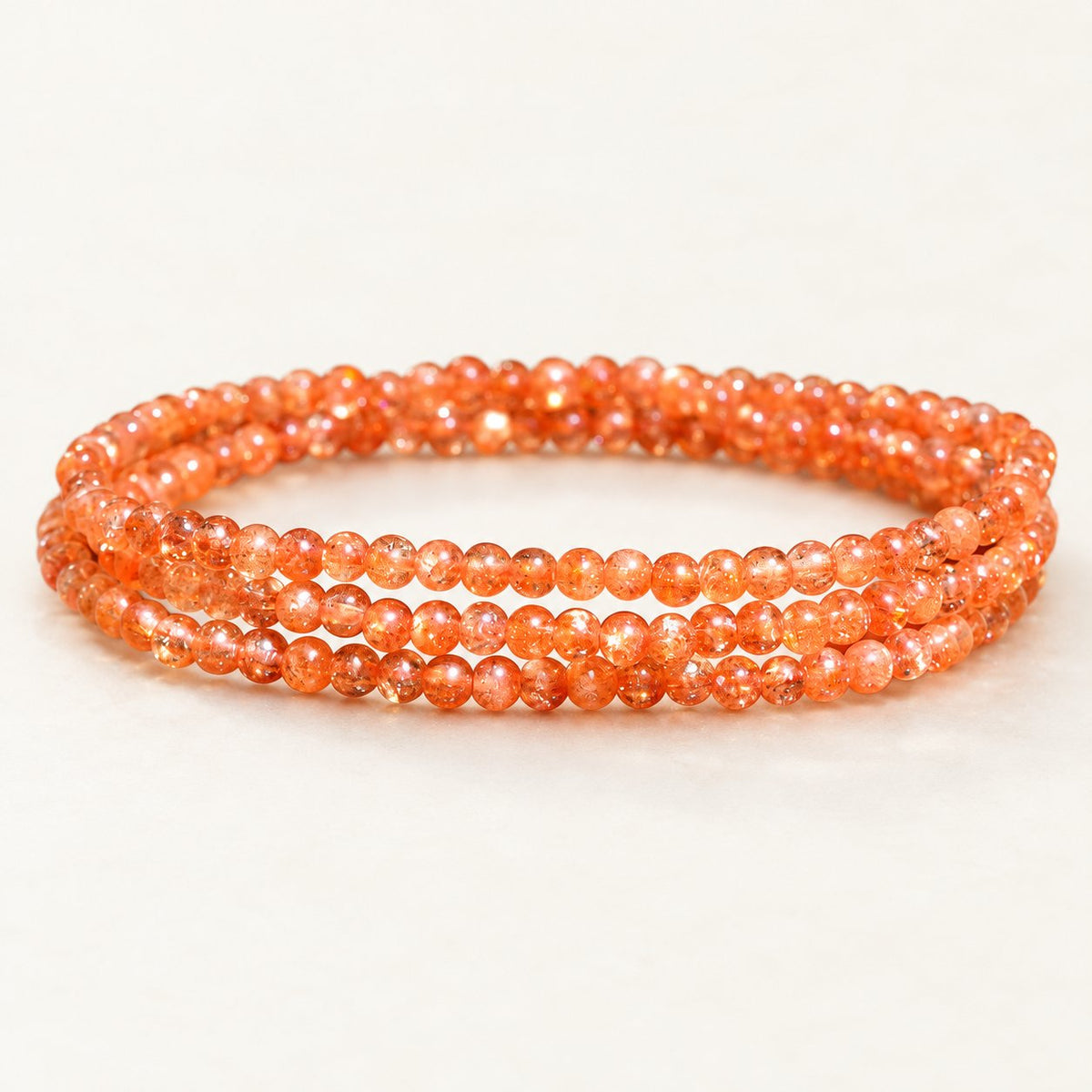 Golden Orbit — Sunstone Wrap Bracelet on a warm ivory studio background