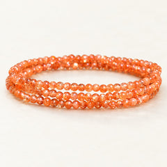 Golden Orbit — Sunstone Wrap Bracelet on a warm ivory studio background