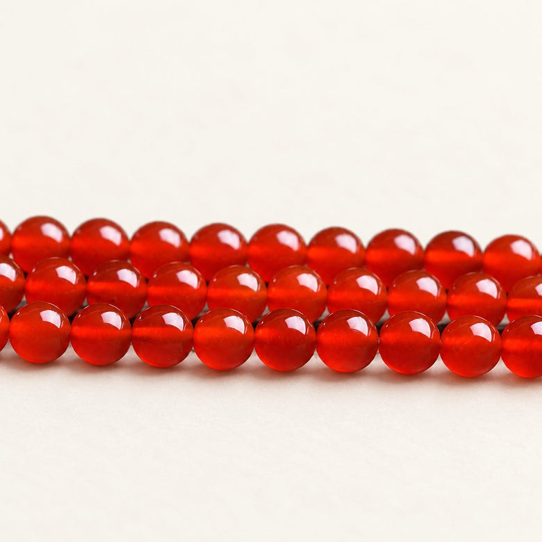 Crimson Reserve — Red Agate Round Beads on a warm ivory background