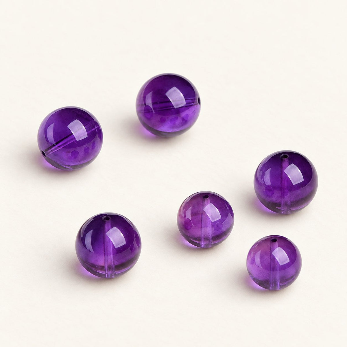 Velvet Violet — Amethyst Round Bead on a warm ivory studio background